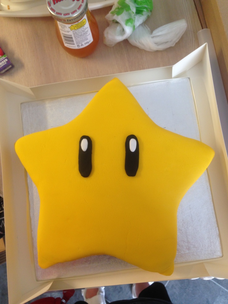 a yellow star shaped cake sitting on top of a white tray next to other items