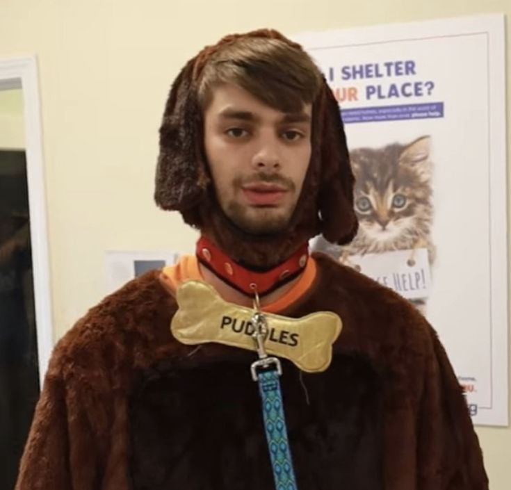 a man wearing a costume with a dog bone on his neck and a cat in the collar