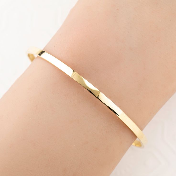 Introducing our exquisite Solid 14K Gold Bangle. Meticulously forged into a flawless oval shape, this bangle epitomizes the artistry of skilled goldsmiths. Crafted from solid 14k gold, its solid construction ensures enduring beauty and resilience. Its robust 3mm width and 1.5mm thickness distinguishes it from more delicate alternatives. The lustrous surface reflects the unparalleled quality of the material, making it a luxurious addition to any jewelry collection.Each bangle will be made to orde Classic Gold Cuff Bracelet With Oyster Detail, Gold-plated Polished Cuff Bracelet For Formal Occasions, Formal Gold Plated Cuff Bracelet With Polished Finish, Formal Gold-plated Polished Cuff Bracelet, Adjustable Yellow Gold Bangle With Polished Finish, Classic Gold Bangle Tarnish Resistant, Minimalist 14k Gold Bracelet With Diamond Cut, Formal Gold Plated Tarnish Resistant Cuff Bracelet, 14k Yellow Gold Tarnish-resistant Bangle