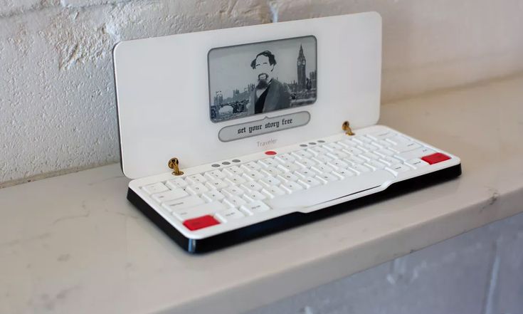 an old computer with a white keyboard and red trim on the front is sitting on a counter