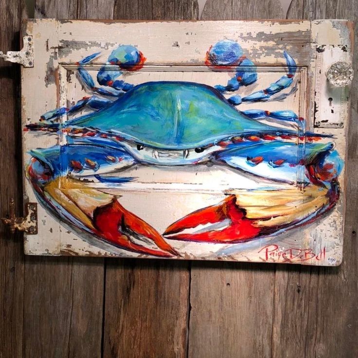 a blue crab is painted on an old door