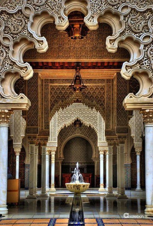 the inside of a building with columns and a fountain in front of an ornate archway