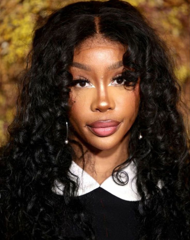 a woman with long curly hair wearing a black shirt