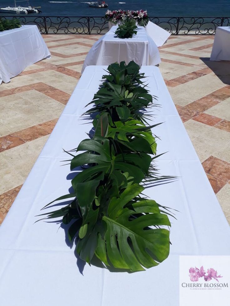 there is a long table with white cloths and flowers on it