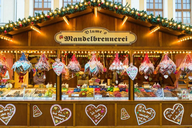 an outdoor market with lots of food and decorations on the outside wall, including heart - shaped candies