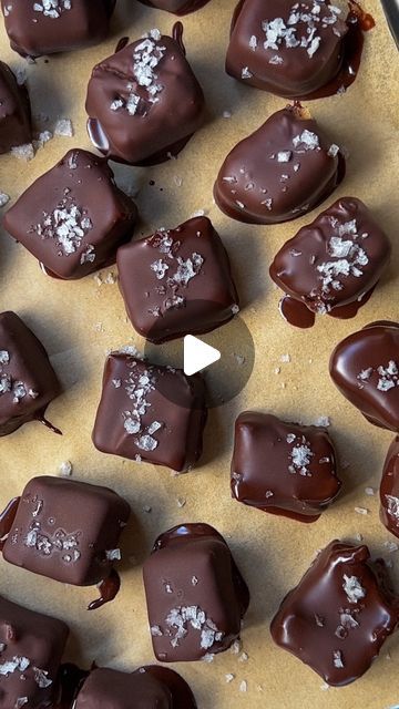 there are many pieces of chocolate on the baking sheet with white sprinkles