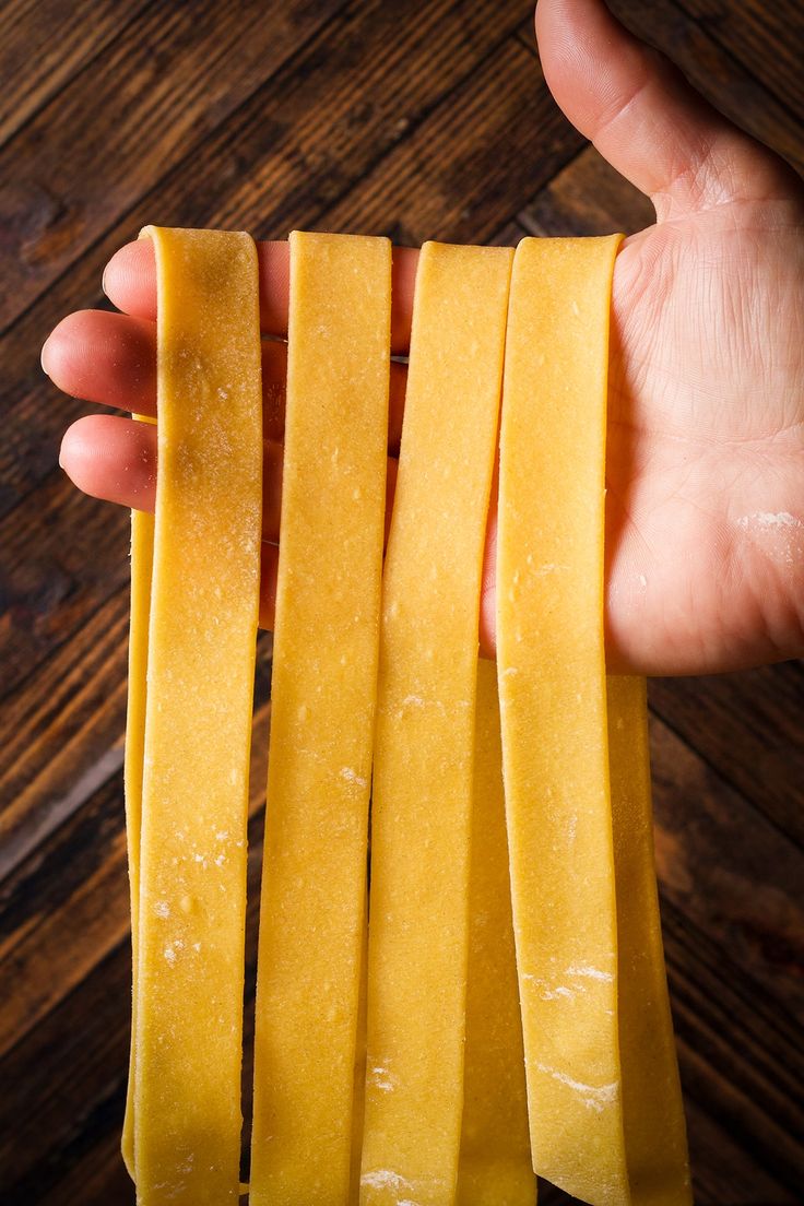 a person holding slices of cheese in their hand