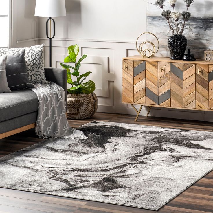 a living room with a gray couch and white rug