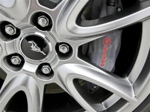 the front wheel of a silver car with black spokes and red lettering on it