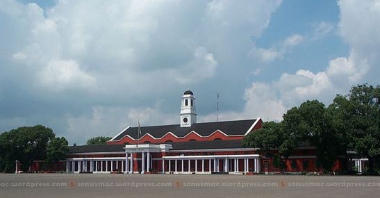 a large building with a clock tower in the middle of it's front yard