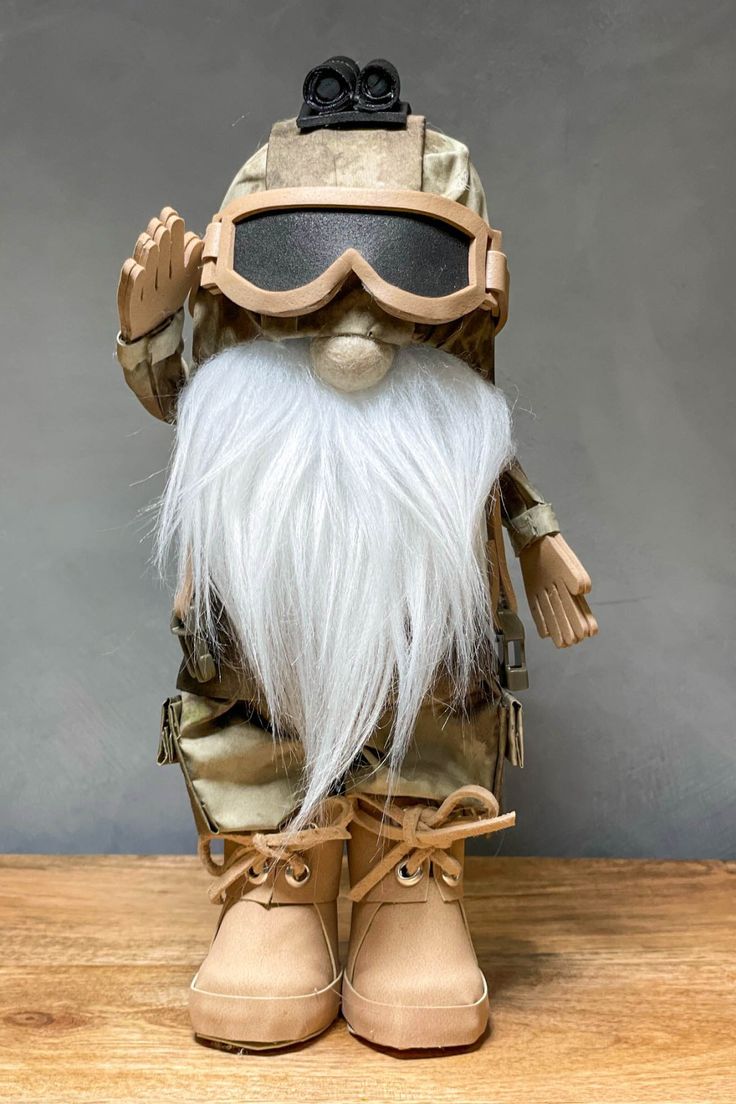 a gnome with white hair and beard wearing goggles on top of a wooden table