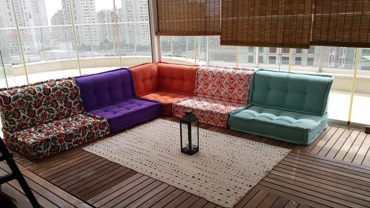 a couch sitting on top of a wooden floor next to a window