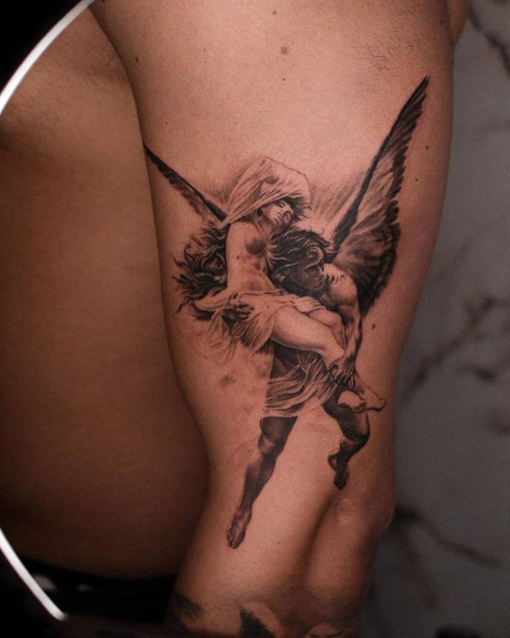 a man with an angel tattoo on his arm holding a woman's back leg