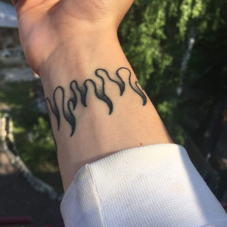 a woman's wrist with black ink on it and three wavy lines in the middle