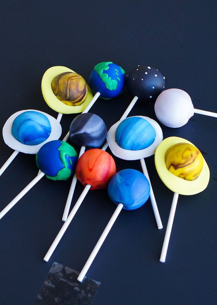 there are many lollipops on the black table and one is different colors