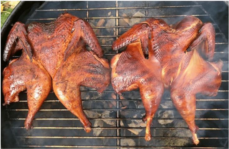 three pieces of meat cooking on a grill