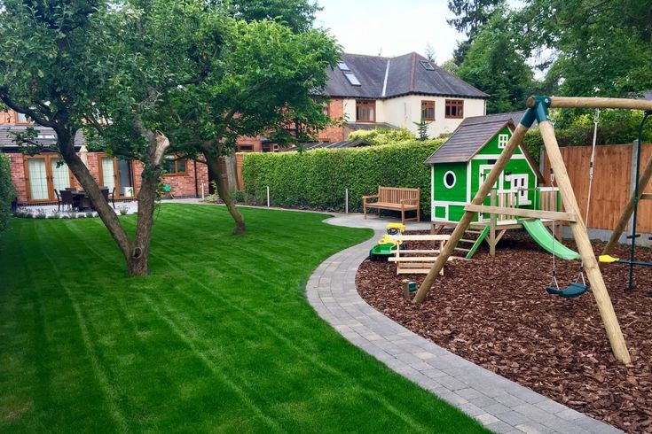 a wooden swing set in the middle of a yard