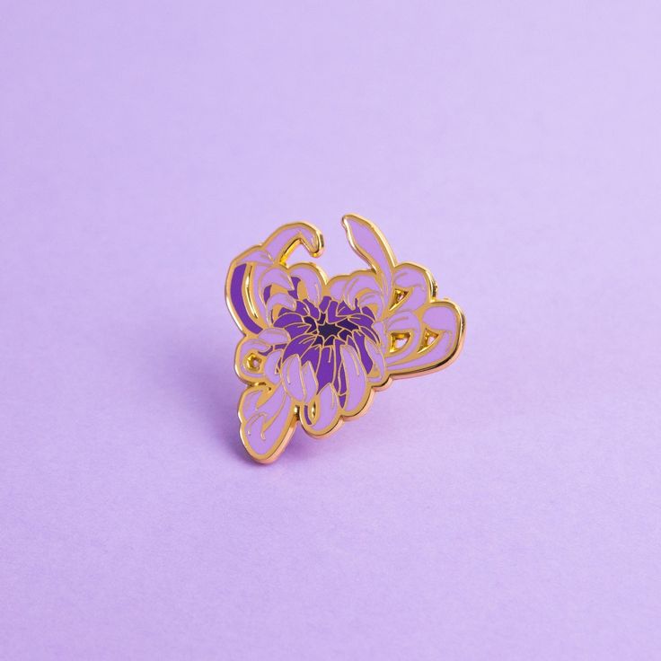 a purple flower pin sitting on top of a purple surface