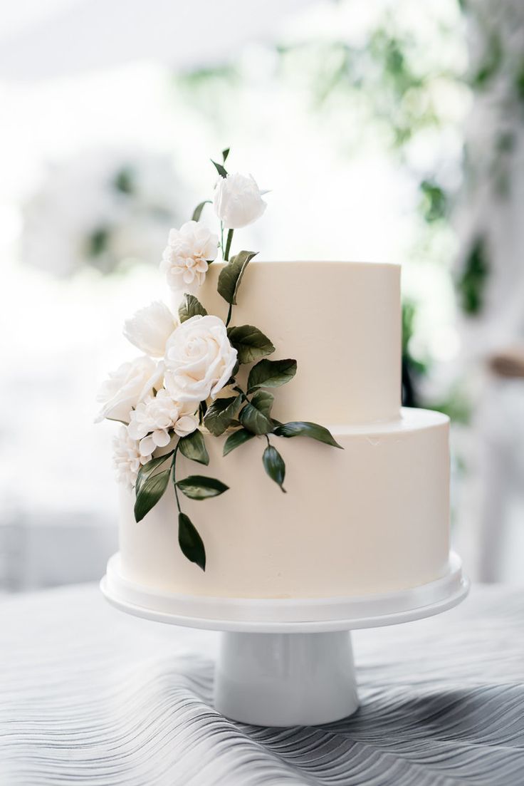 a wedding cake with white flowers and greenery