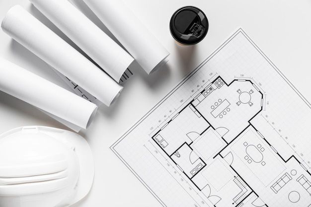 architectural drawings and tools on top of a blueprinted floor plan for a new home