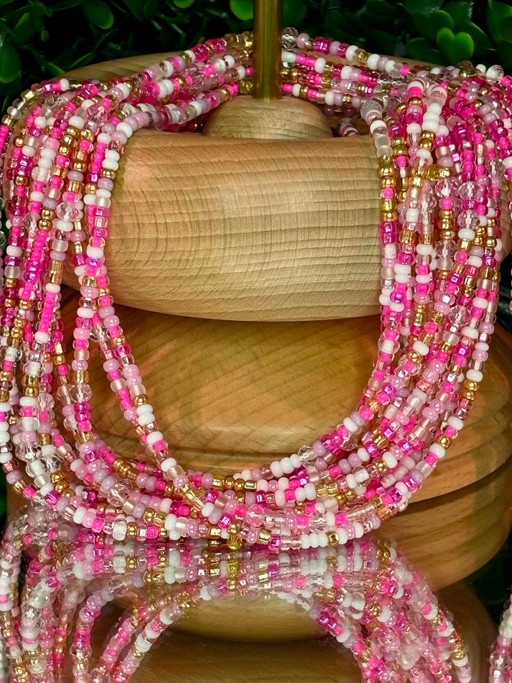 **Please allow up to 5-7 business days for processing time for Waistbeads, Free US Shipping for orders over $75 ** Our stunning Barbie Waistbeads, are perfect for adding a touch of elegance and tradition to your style. These waistbeads feature a beautiful pink colors, accented with splashes of gold beads throughout. Crafted with high-quality 8/0 and 6/0 glass beads, they offer both durability and beauty. Designed to fit most with a standard length of 60", these traditional tie-on waistbeads allo Pink And Gold Waist Beads, Pink Hand-strung Jewelry For Festival, Hand-strung Pink Jewelry For Festivals, Pink Hand-strung Beaded Necklaces For Festival, Festival Pink Hand-strung Beaded Necklaces, Festival Hand-strung Pink Beaded Necklaces, Hand-strung Pink Beads For Festivals, Pink Multi-strand Jewelry With Polished Beads, Spiritual Pink Spacer Beads