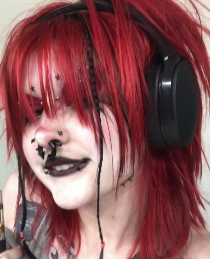 a woman with red hair wearing headphones and makeup