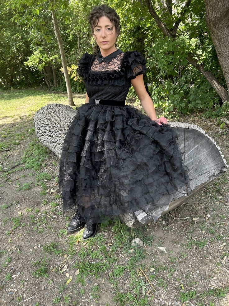 "This is a recreation of the beautiful Raven dress for Wednesday's infamous dance.   The dress is made of a beautiful black lace for the bodice and sleeves with the iconic collar made of Casa matte satin.  The collar is embellished with a gorgeous jeweled button.  The bodice is lined and embellished with an elegant and beautiful triple tier lace. The skirt is made of tier upon tier of ruffled organza and lined with a taffeta and tulle under skirt.  A velvet belt with a beautiful \"buckle\" compl Costume Party Dresses With Lace Trim, Lace Dresses With Lace Trim For Costume Party, Black Prom Dress With Attached Cancan, Halloween Evening Dress With Lace Trim, Victorian Dress With Lace Trim For Party, Fitted Black Dress With Lace Collar, Gothic Lace Dress For Formal Occasions, Gothic Lace Dress For Evening, Gothic Lace Dress For Party