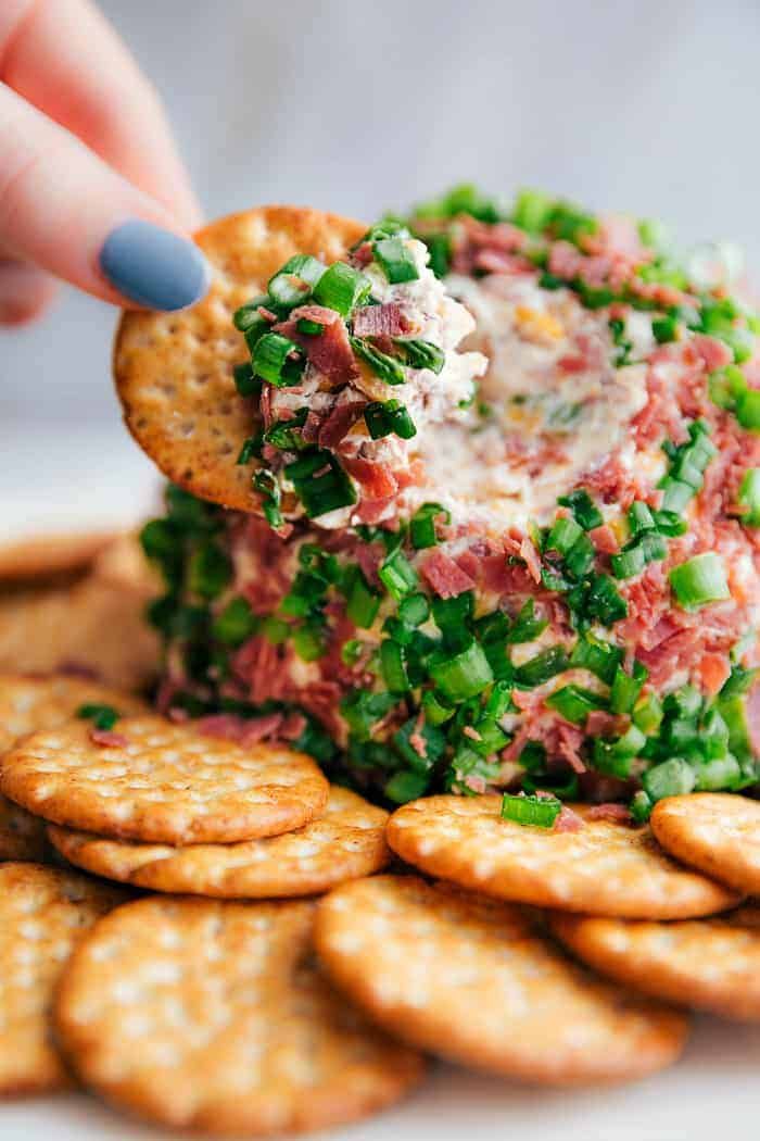 a cracker being dipped with crab salad on top of crackers