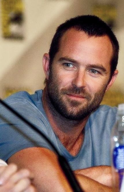 a man sitting at a table with a bottle of water