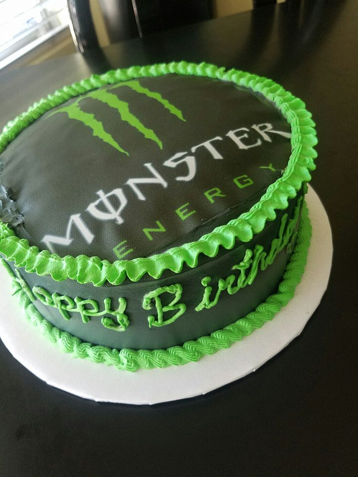 a birthday cake with green frosting and the words monster energy on it is sitting on a table