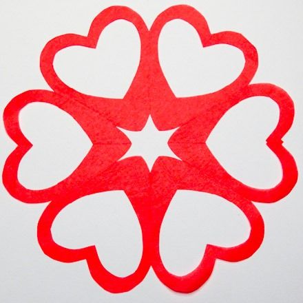 a red paper cutout with hearts on it