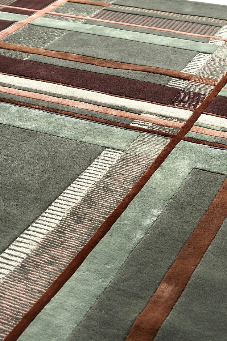 an area rug with various colors and designs on it, including brown, green, blue, and white stripes