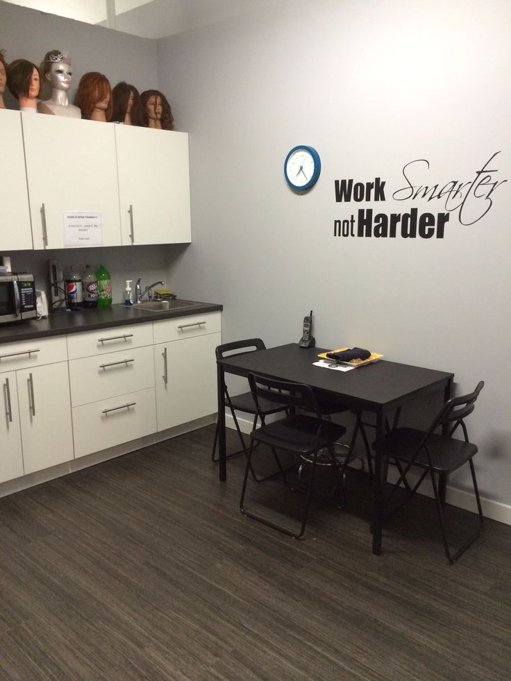 a kitchen with white cabinets and black table in front of a wall that says work, not harder