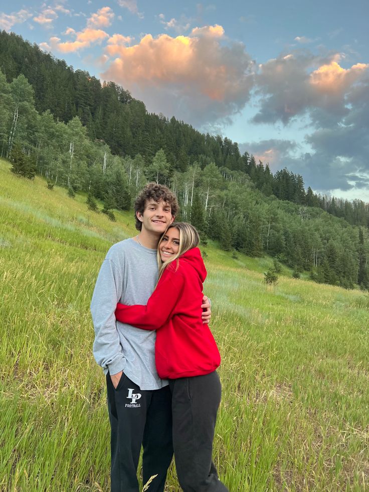 a man and woman hugging in a field