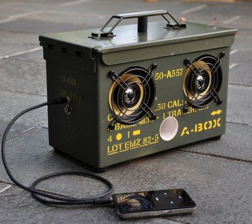 a speaker box sitting on the ground next to a cell phone