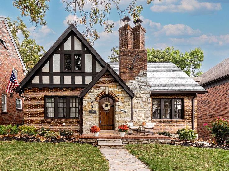 a brick house with an american flag on the front lawn