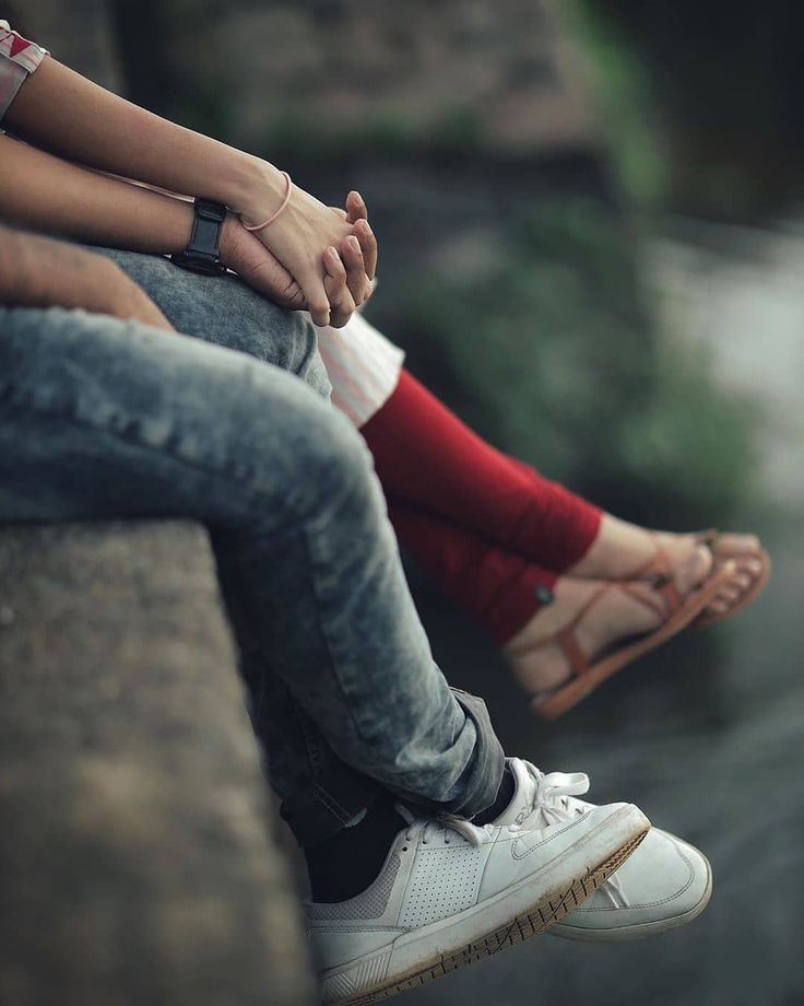 two people sitting next to each other with their hands on their knees and feet crossed