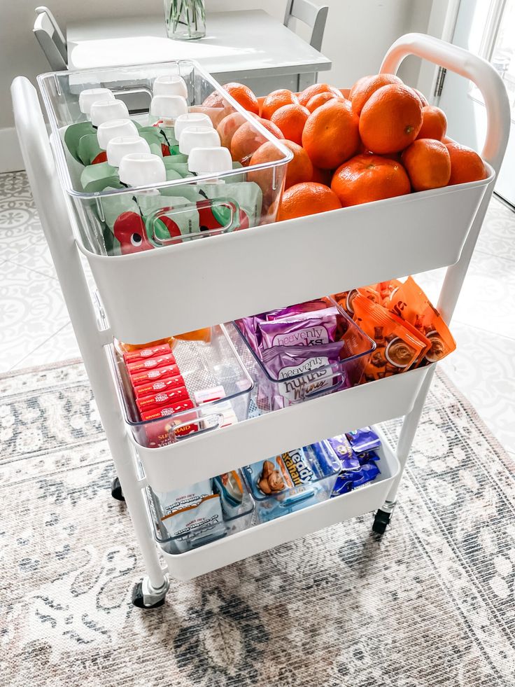 a cart filled with oranges and drinks on top of a carpeted room floor