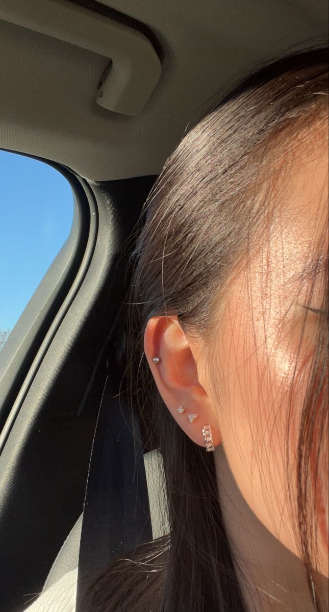 a woman with ear piercings sitting in a car