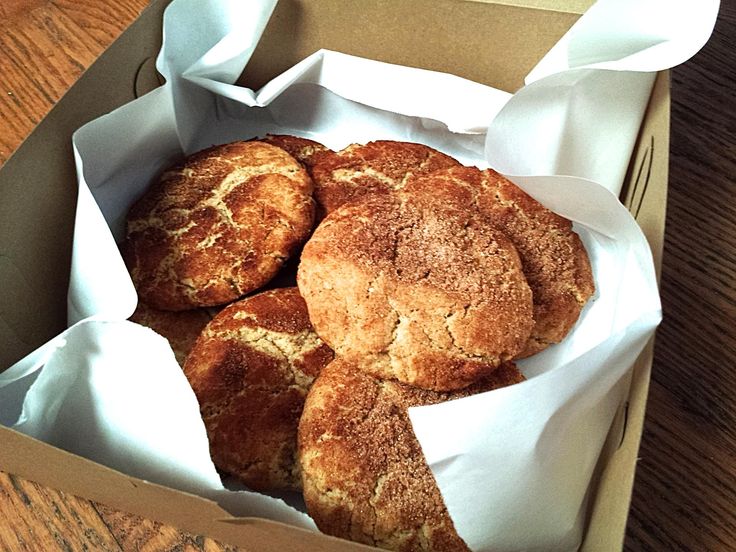 a box filled with pastries sitting on top of a wooden table