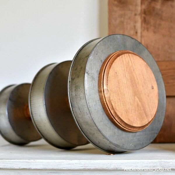 three metal containers with wooden lids sitting on a shelf