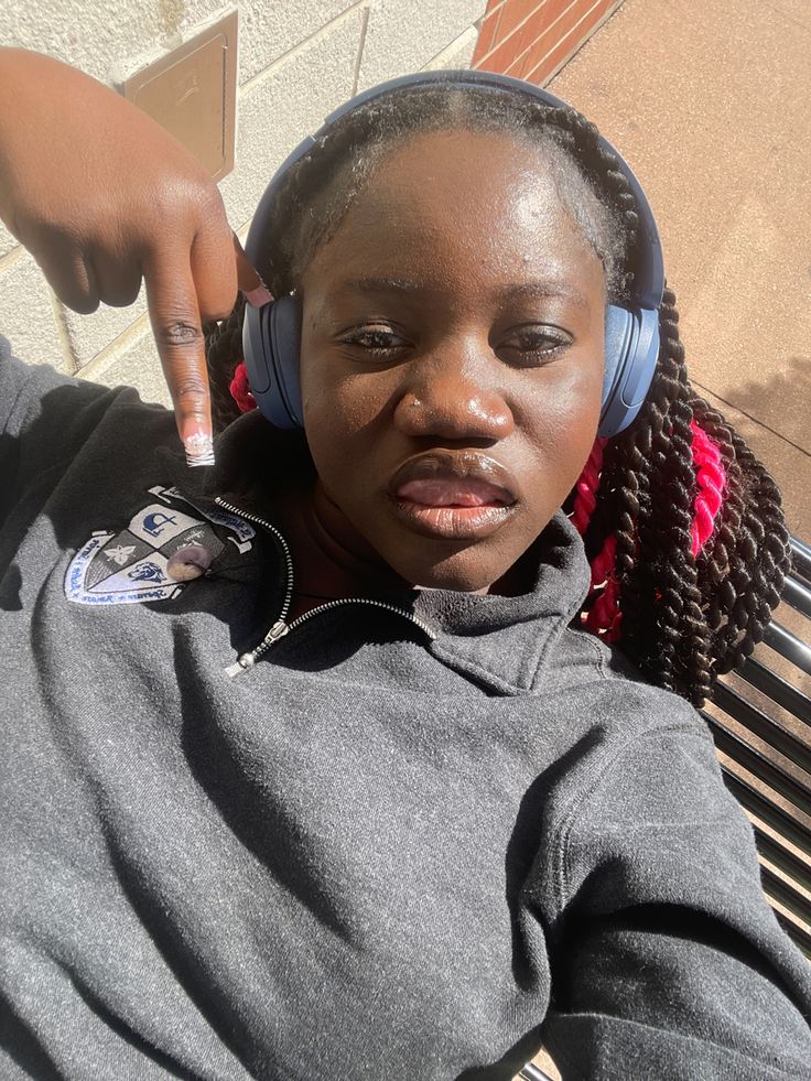 a woman sitting on a bench with headphones around her neck