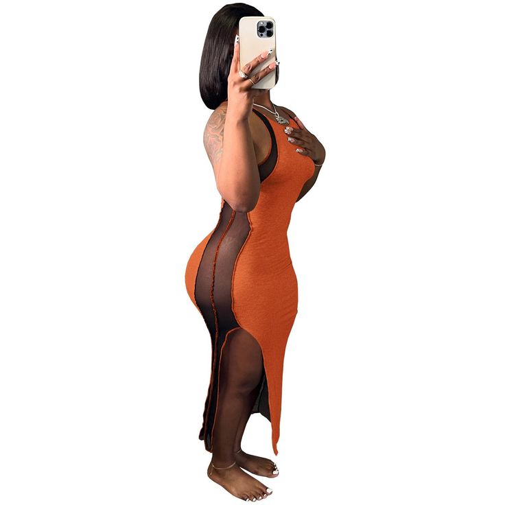 a woman in an orange and black dress taking a selfie with her cell phone