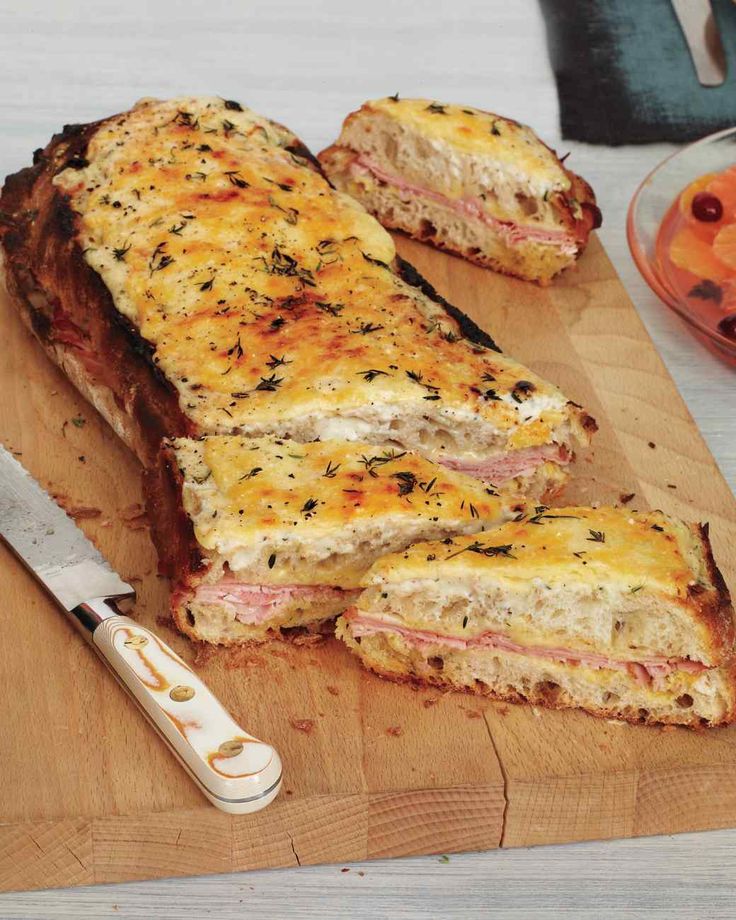 ham and cheese sandwich cut in half on cutting board with knife