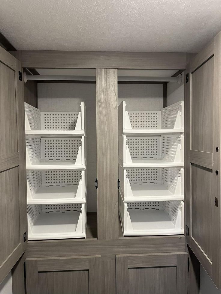 an empty pantry with two doors open and shelves in the middle, all lined up