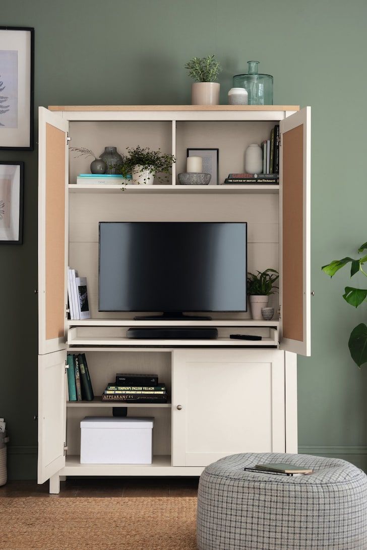 a living room with green walls and a white entertainment center