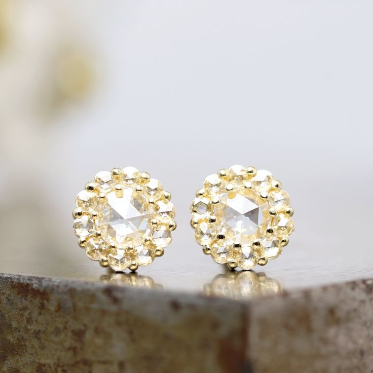 "This pair of 14k yellow gold stud earrings showcases natural rose cut diamond center stones surrounded by a sparkling white rose cut diamond halo. These gold earrings are the ultimate small everyday fancy luxury and are ready to ship. The 4mm center diamonds are a clear rose cut stone, beautifully cut and polished.  Surrounding the rose cut center stone are 10 small, natural white rose cut diamonds in each earring, for a total of 20. Each measures 1.5mm. The diamonds are prong set into the yell Gold Diamond Earrings With Rose Cut Cubic Zirconia, Gold Cubic Zirconia Diamond Earrings With Rose Cut, Rose Cut Diamond Earrings In 14k Gold, Gold Rose Cut Diamond Earrings, Anniversary Yellow Gold Earrings With Rose Cut Diamonds, Dazzling Rose Cut Diamond Earrings For Anniversary, Anniversary White Gold Rose Cut Diamond Earrings, Diamond White Rose Cut Diamond Earrings As Gift, Yellow Gold Rose Cut Diamond Anniversary Earrings