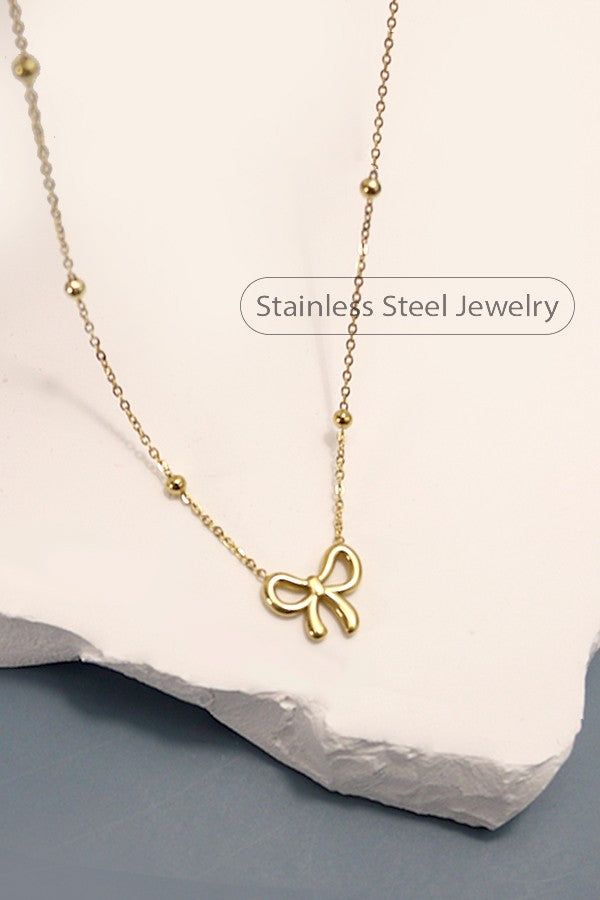 18K Stainless Steel Non-Tarnish Bow Necklace with Station Ball Chain, a crafted from premium stainless steel with a luxurious 18K gold finish, this necklace features a graceful bow pendant suspended on a station ball chain. Product Details:length: 17"Charm size: .5"ext: 3" extclasp: Lobster ClawMetal finish: Stainless Steel 18K Goldproduct: Lead & Nickel Compliantanti-tarnish: Tarnish Free, Non-Tarnish Real Gold Dipped NecklaceStainless Steel NecklaceHypoallergenic NecklaceTarnish-Free NecklaceN Small Gold Necklace, Bow Pendant, Pendant Necklace Simple, Gold Necklace Simple, Sunglass Chain, Bow Necklace, Bow Jewelry, Small Bows, Gold Dipped