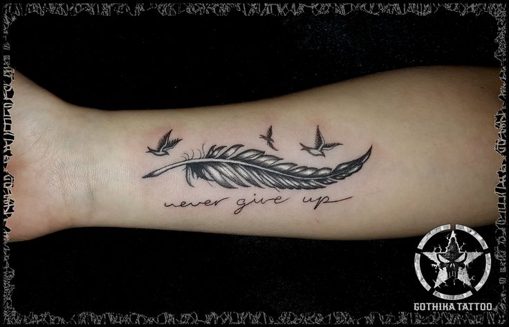 a woman's arm with a tattoo that reads never give up and birds flying around