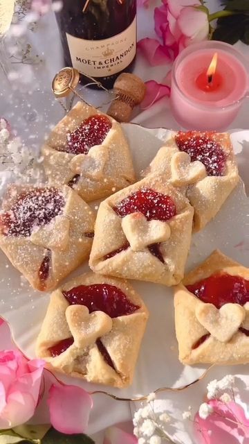 small pastries on a white plate with pink flowers and candles in the back ground